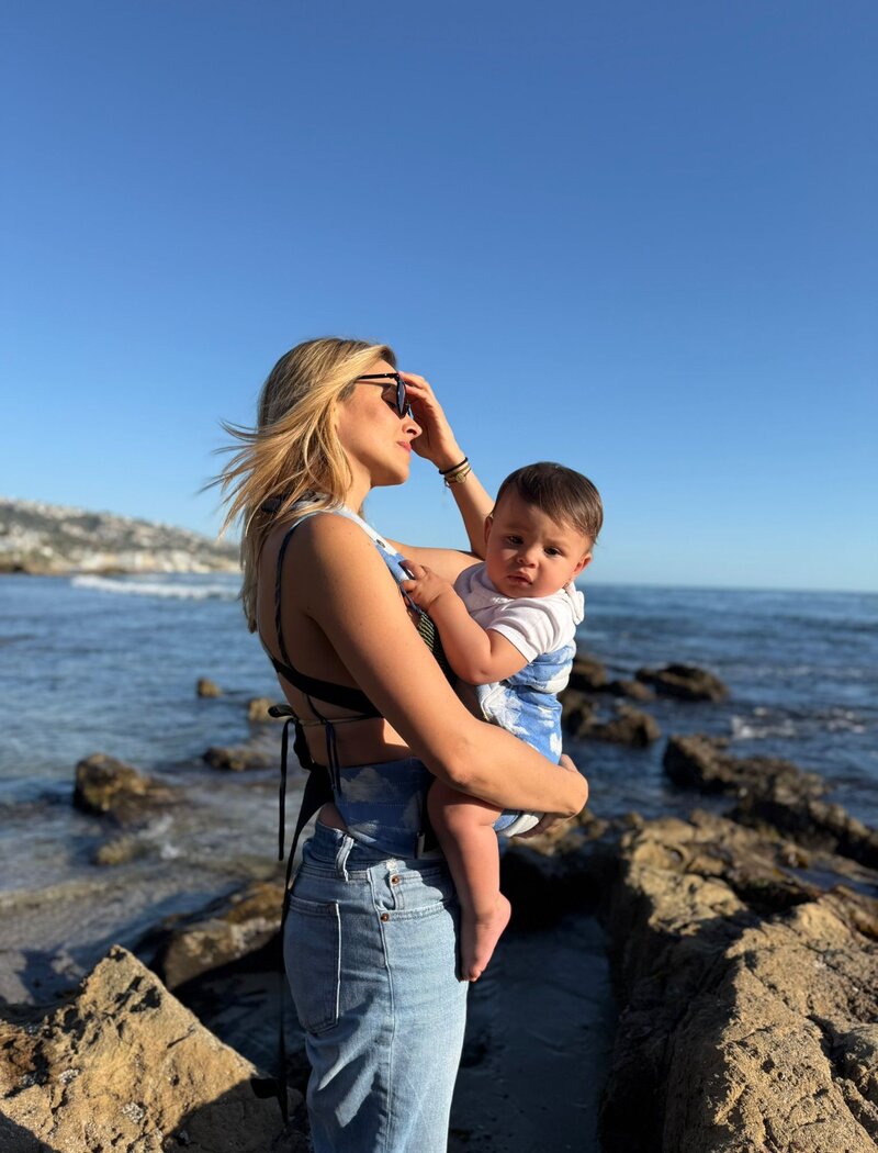 Yessenia Hernandez, President of Materaqua, standing by the ocean with her daughter